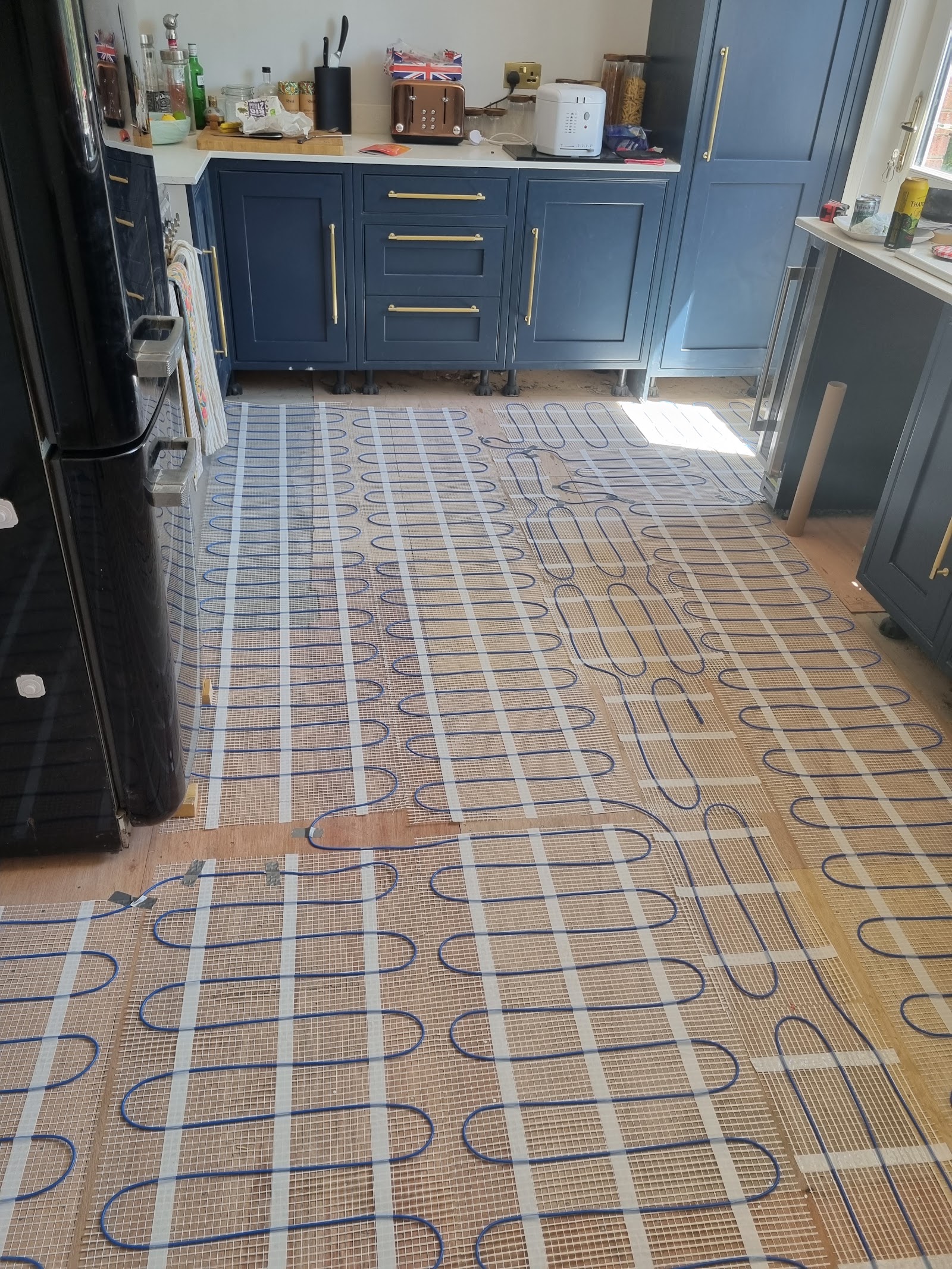 Electric underfloor heating laid across a kitchen floor before flooring goes down